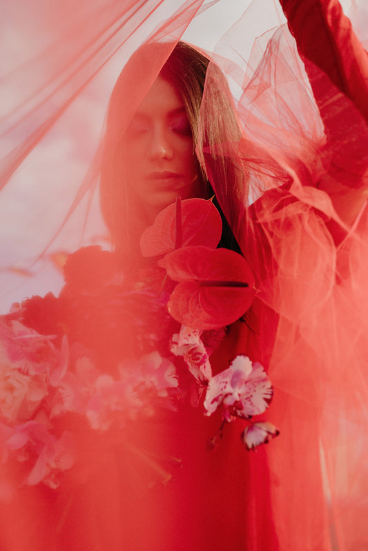 A dramatic head to toe crimson red tulle bridal veil for a bold, alternative wedding look.